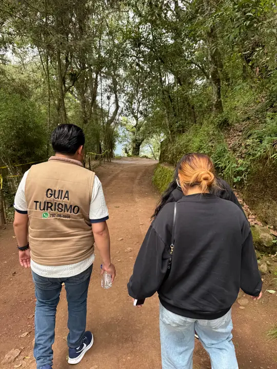 Guía de turismo acompañando a una visitante en el sendero