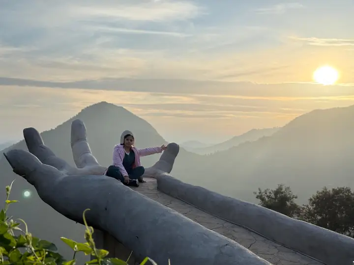 Visitante sentada en la Mano Gigante al amanecer