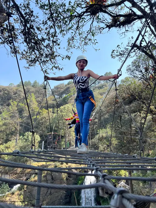 Visitante con equipo de seguridad en el puente colgante de Quetzalapan